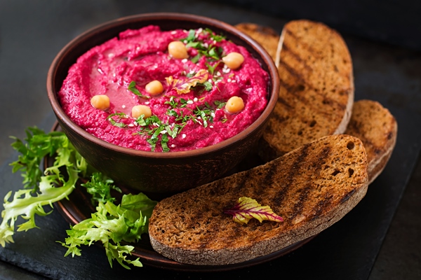 roasted beet hummus with toast in a ceramic bowl on a dark table - Галеты со свекольным хумусом