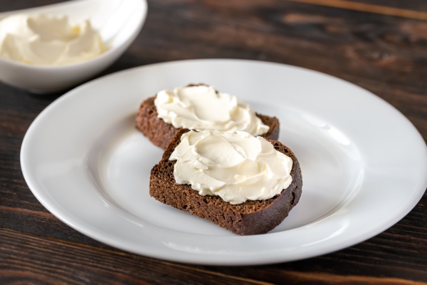 slices of rye bread with cream cheese on white plate - Бутерброды с кешью-массой и помидорами черри