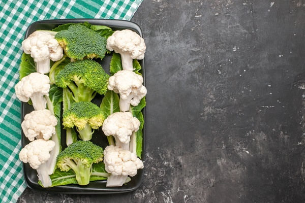 top view raw broccoli and cauliflower on black rectangular plate on green and white checkered napkin on dark surface with copy space - Минестроне, постный стол