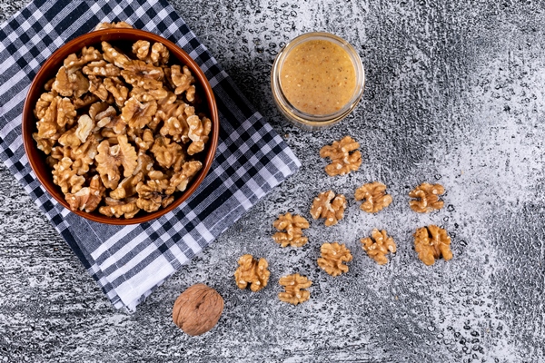 top view walnuts in bowl and nuts butter on stone horizontal - Постные баклажанные рулеты с орехами