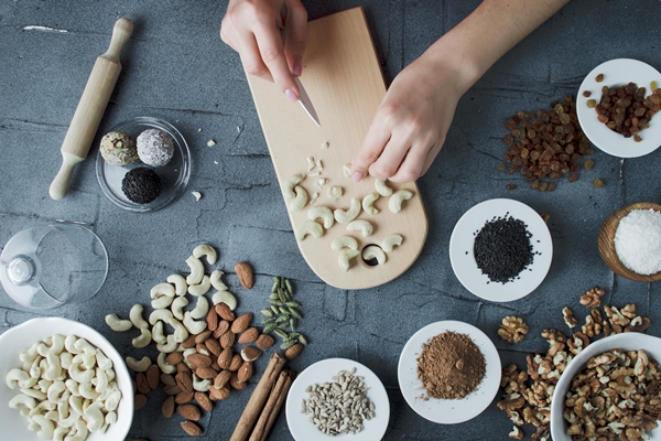 woman makes natural candies from nuts and dried fruits at home top view - Основы сухоядения