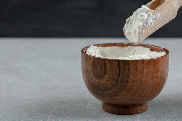 a wooden bowl of flour and wooden spoon - Горячий шоколад по-мексикански