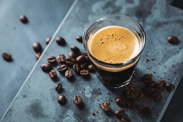 closeup of classic fresh espresso served on dark surface - Кофе бичерин