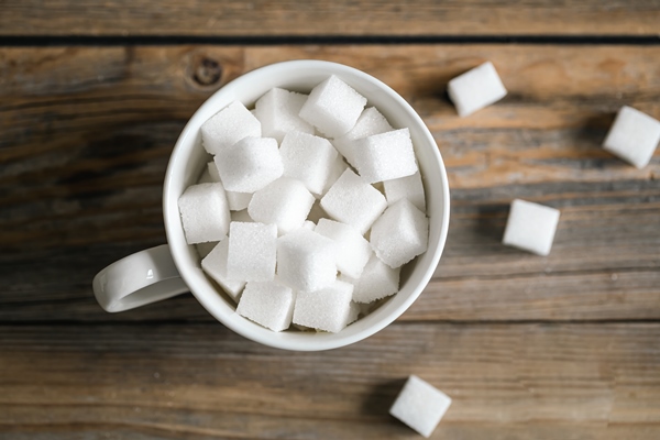 cup with sugar cubes on a wooden surface closeup 1 - Чай масала