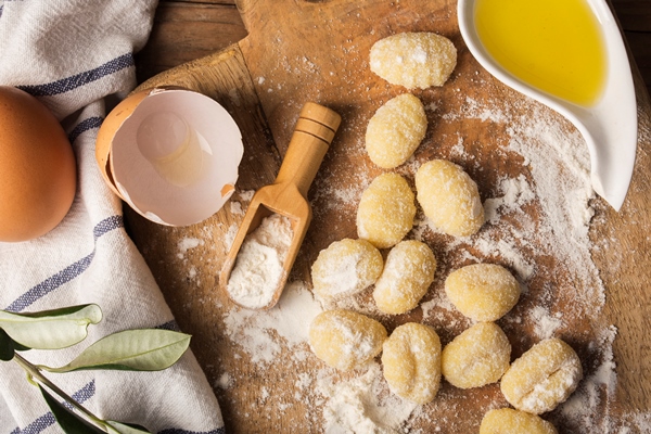 flat lay uncooked potato gnocchi on cutting board - Бульон с клёцками