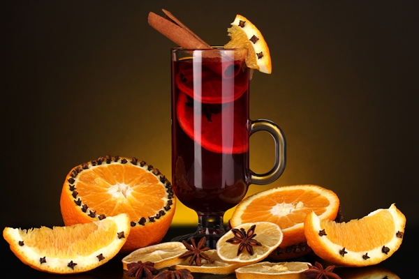 Безалкогольный глинтвейн на смеси соков fragrant mulled wine in glass with spices and oranges around on yellow background - Безалкогольный глинтвейн на смеси соков