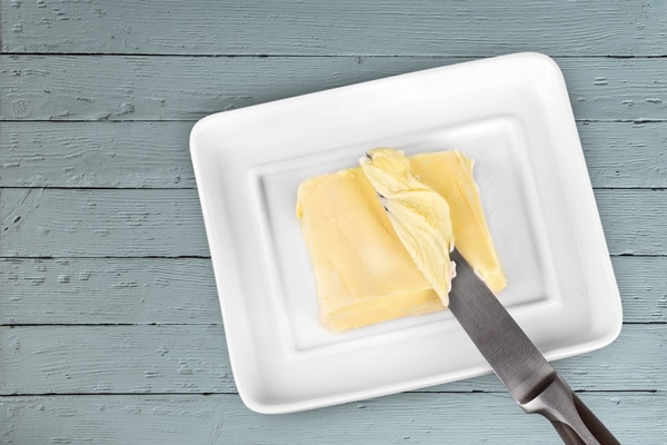 sliced fresh butter curls in white container on wooden table - Французские тосты с яйцом