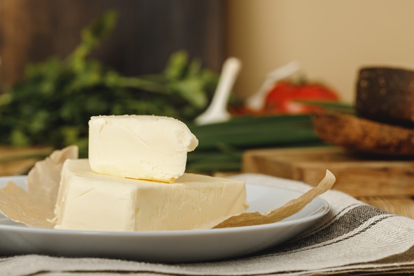 slices of butter in a plate on wooden table close up - Стручковая фасоль с яйцом