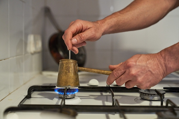 unrecognizable person brewing coffee on gas stove - Американо