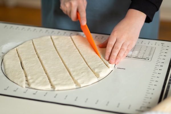 women s hands cut the dough for baursaks cooking central asian pastries - Баурсаки