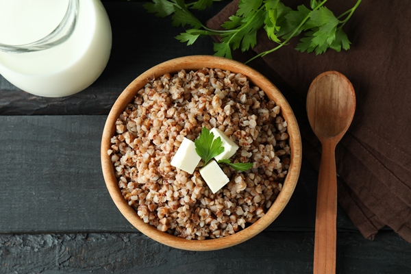 concept of tasty eating with buckwheat on wooden table - Гречневая каша с молоком