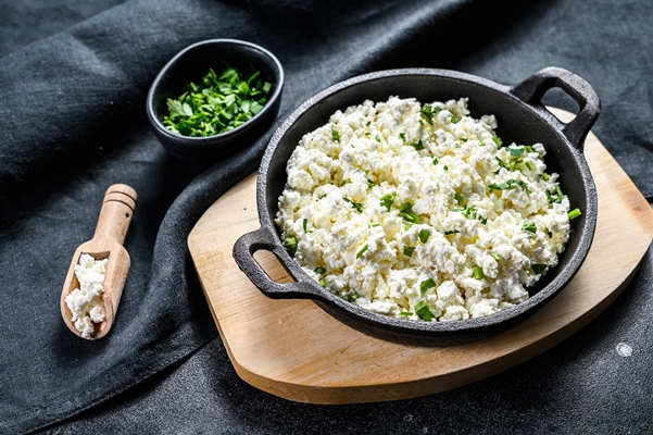 Творог с молодой зеленью cottage cheese in a cast iron bowl with herbs - Творог с молодой зеленью
