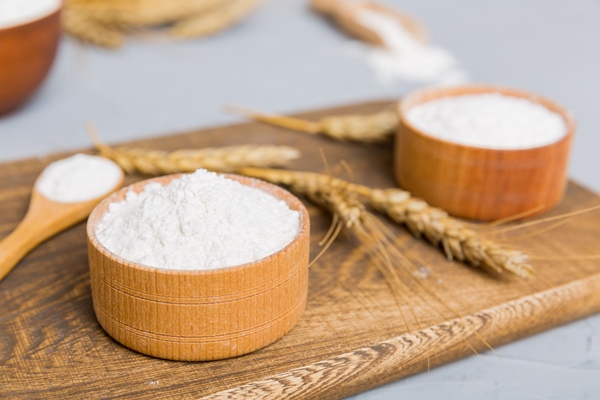 flat lay of wheat flour in wooden bowl with wheat spikelets on colored background world wheat crisis - Сладкий молочный соус