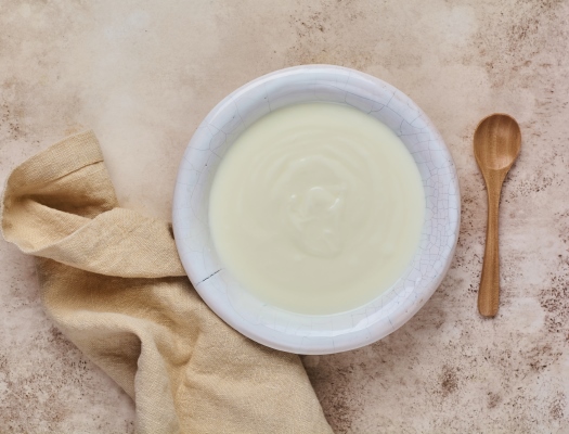 greek yogurt in white bowl linen napkin and wooden spoon on old beige table top view - Сливочный суп-пюре из салата