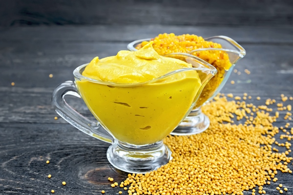 mustard sauce and dijon mustard in two glass saucepans seeds on a wooden board background - Постный томатный соус