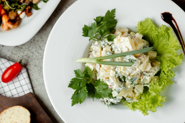 russian salad on the table with bread - Мясной салат