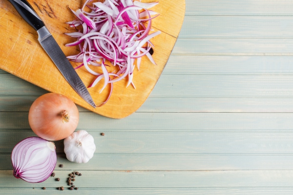 sliced red onion and kitchen knife on wooden board - Грибы с овощами под сырным соусом