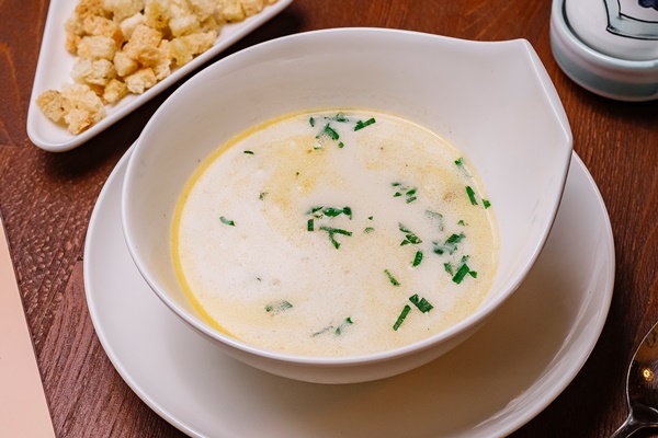 top view of creamy chicken soup bowl garnished with parsley served with bread stuffing - Молочный рисовый суп