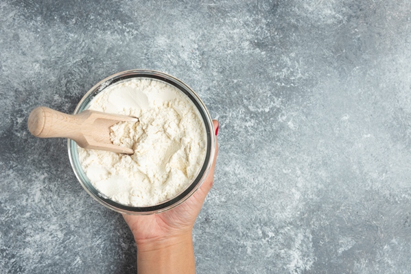 woman hand holding glass bowl of flour on marble - Рыбный суп-пюре