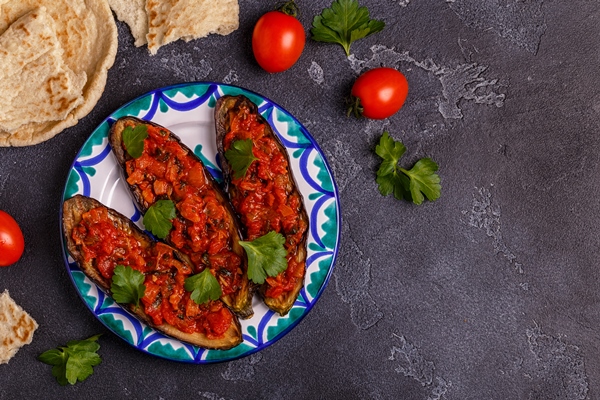 baked eggplant with tomatoes onion garlic and parsley top view - Баклажаны, фаршированные грибами