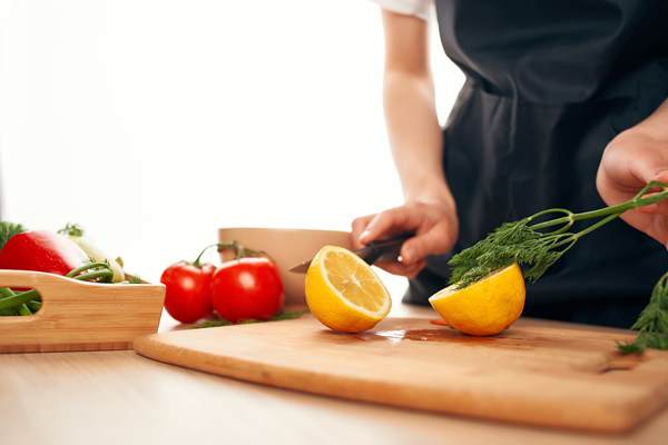 chef with a knife in his hands cuts vegetables and lemon kitchen home cooking - Монастырская кухня: оладьи из картофеля, жареные яблоки и сорбет