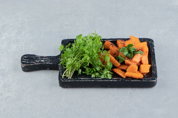 cooked sliced pumpkin next to parsley on the tray on the marble background - Монастырская кухня: густой суп из чечевицы и тыквы, лепёшки с зеленым луком