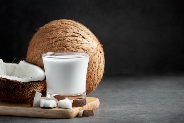 glass of coconut milk put on wooden cutting board - Паста из грецких орехов