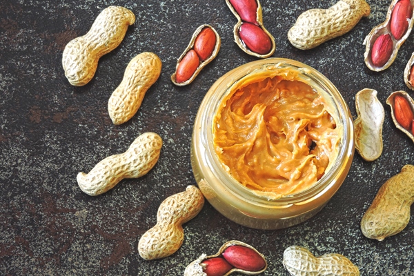 peanut paste and peanuts vegan snack keto snack vegetable protein concept - Арахисовая паста с кленовым сиропом