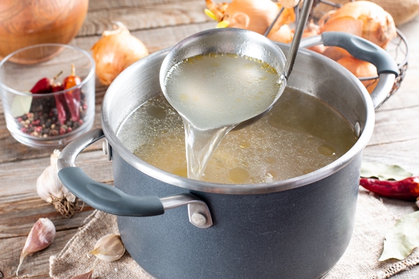 saucepan with bouillon with a ladle on the table bone broth - Соус с хреном для отварного языка и мяса