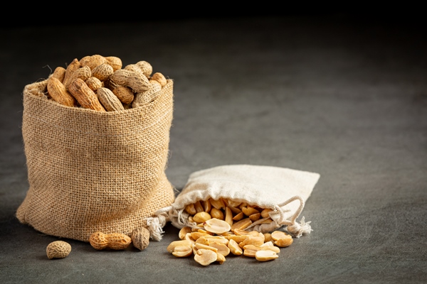 two sack of groundnuts put on dark background - Арахисовая паста