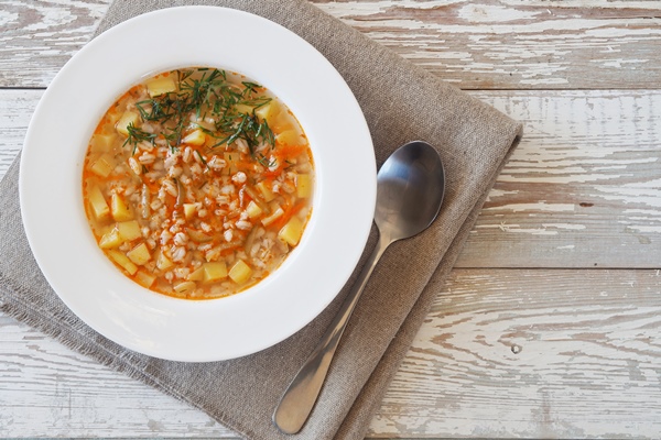 vegetable soup with cereals and pickles in a white bowl on rustic wooden table - Монастырская кухня: ржаные пирожки с горохом, постный рассольник