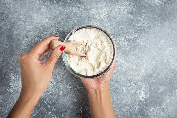 woman hand holding spoon inside of flour bowl - Морковная бабка