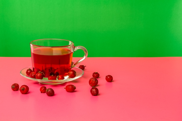 Особенности питания детей a cup with an infusion of dried rosehip berries on a table with reflection bright background - Особенности питания детей