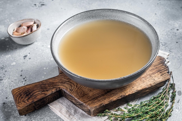 bone meat chicken broth plate gray background top view - Мясной обезжиренный бульон с гренками