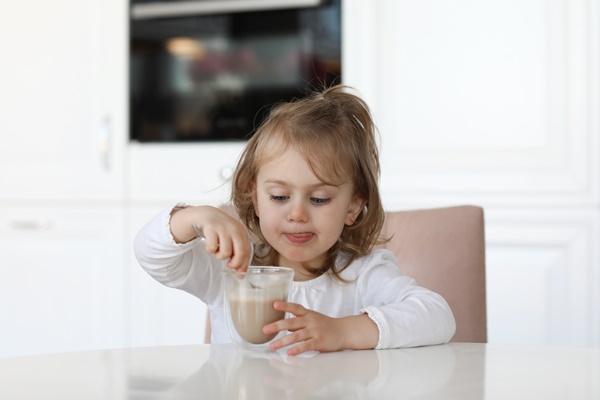 Особенности питания детей child girl in white kitchen at home drink cocoa - Особенности питания детей