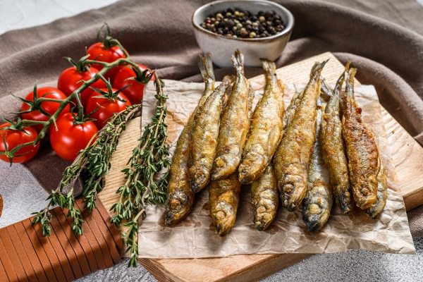 fried smelt sprats small fried fish gray background top view - Жареная корюшка