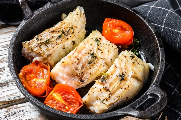 grilled pollock or coalfish fillets in a pan white background top view - Камбала, запечённая с шалфеем