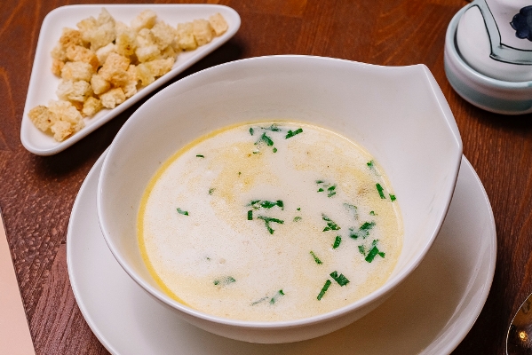 top view of creamy chicken soup bowl garnished with parsley served with bread stuffing - Суп перловый слизистый на молоке с яйцом