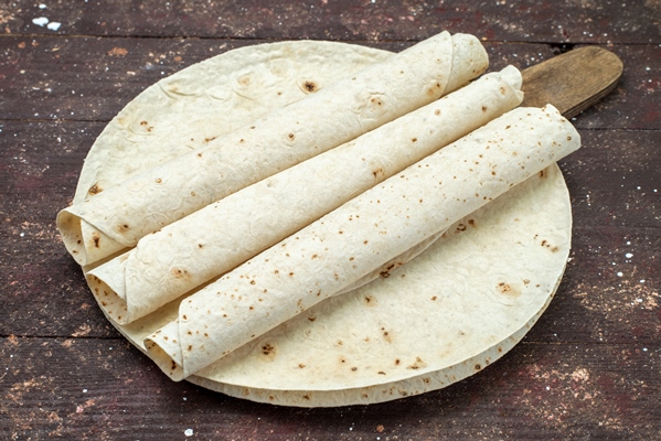 top view round lavash and rolled dough bread like on the brown wooden desk food meal pastry dough - Лаваш с фасолью