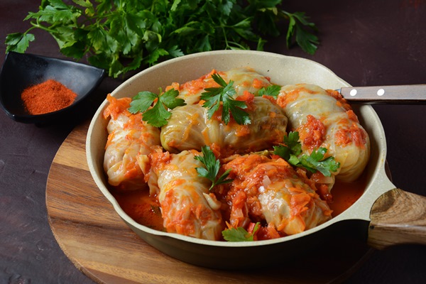 cabbage rolls stuffed with ground beef and rice in tomato sauce - Голубцы из листьев лопуха мясные