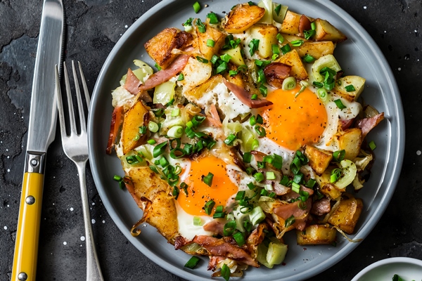 potatoes ham eggs breakfast hash on a dark background top view delicious nutritious breakfast snack - Картофель, жаренный с черемшой и яйцом