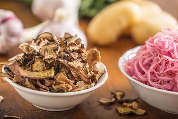 sour cabbage and dried mushrooms in bowl on wooden table - Пельмени с грибами по-монастырски