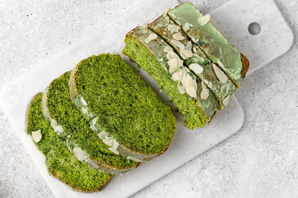 Хлеб с лебедой spinach cake with flaked almonds cutted on marble board grey background top view - Хлеб с лебедой
