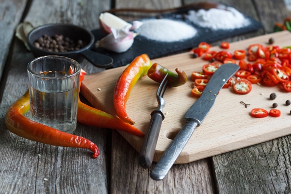 close up of chopped hot chili peppers and heaps of salt sugar garlic allspice bay leaf on an old wooden surface - Баклажаны с чесноком "Шашлычные"