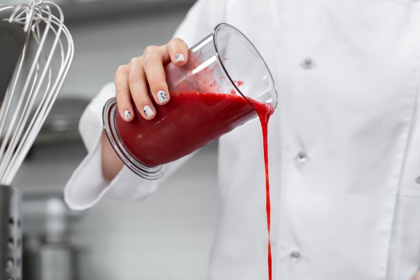 pastry chef pours strawberry puree into a saucepan - Холодный фруктовый суп