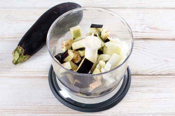 chopped eggplant in a blender on wooden table - Драники из картофеля и баклажанов