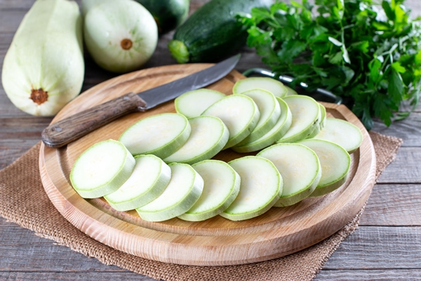 whole and sliced fresh zucchini on wooden table healthy vegetarian ingredient - Острая закуска из кабачков "Тёщин язык"