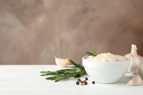 bowl of garlic sauce ingredients on white table against brown background space for - Мойва с овощами в горшочках