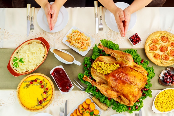 family holding hands over table setting and praying - Яблочная приправа-взвар