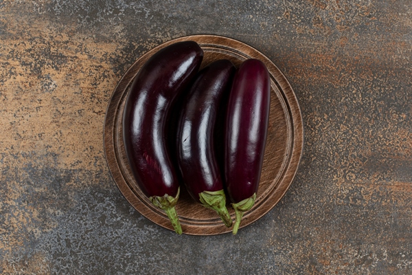 fresh raw eggplants on the board on the marble surface - Баранина по-индийски